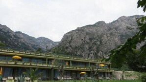 Un hôtel doté d’une terrasse offrant une vue sur un paysage montagneux.