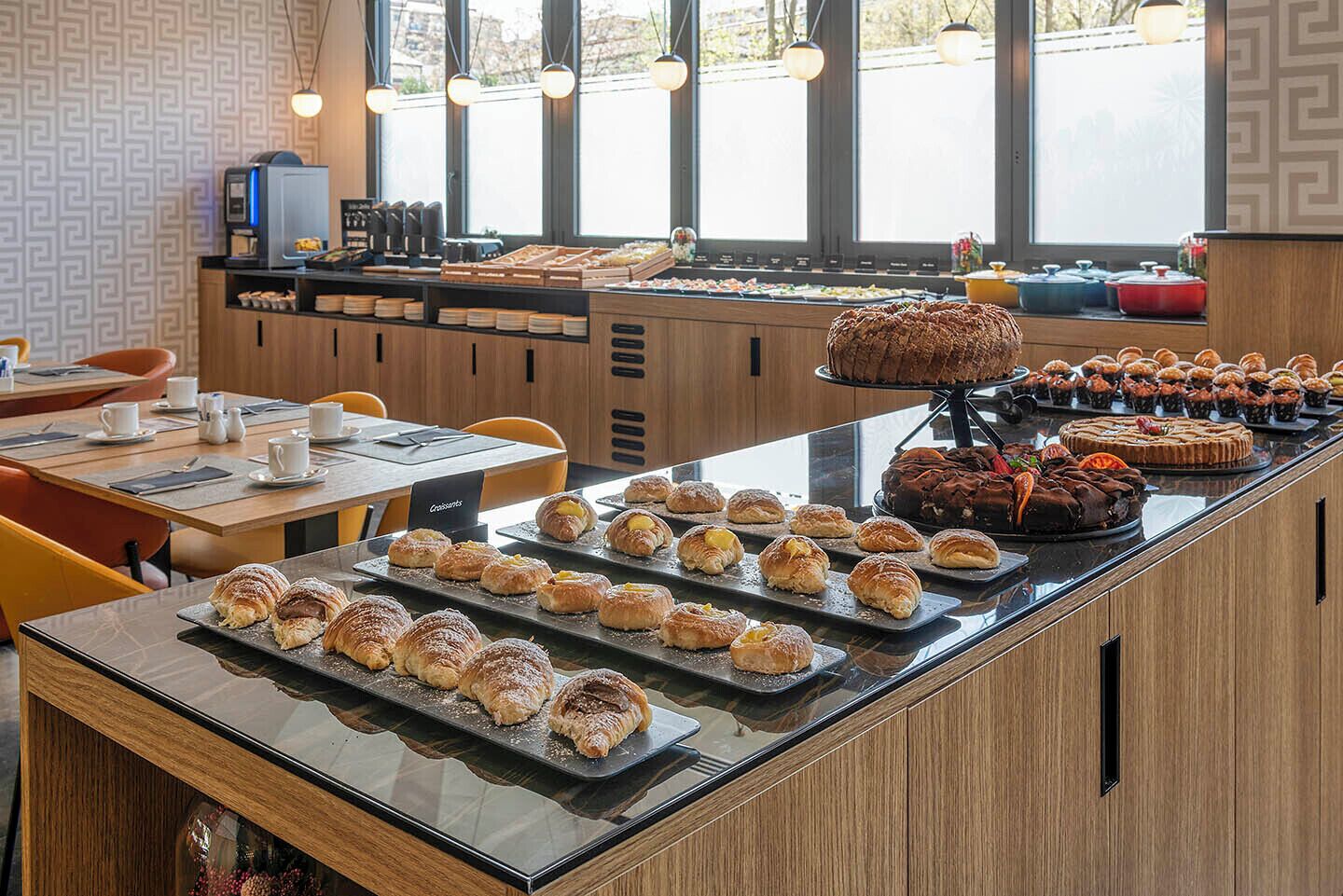 Mostrador de una panadería con pasteles y una estación de café.
