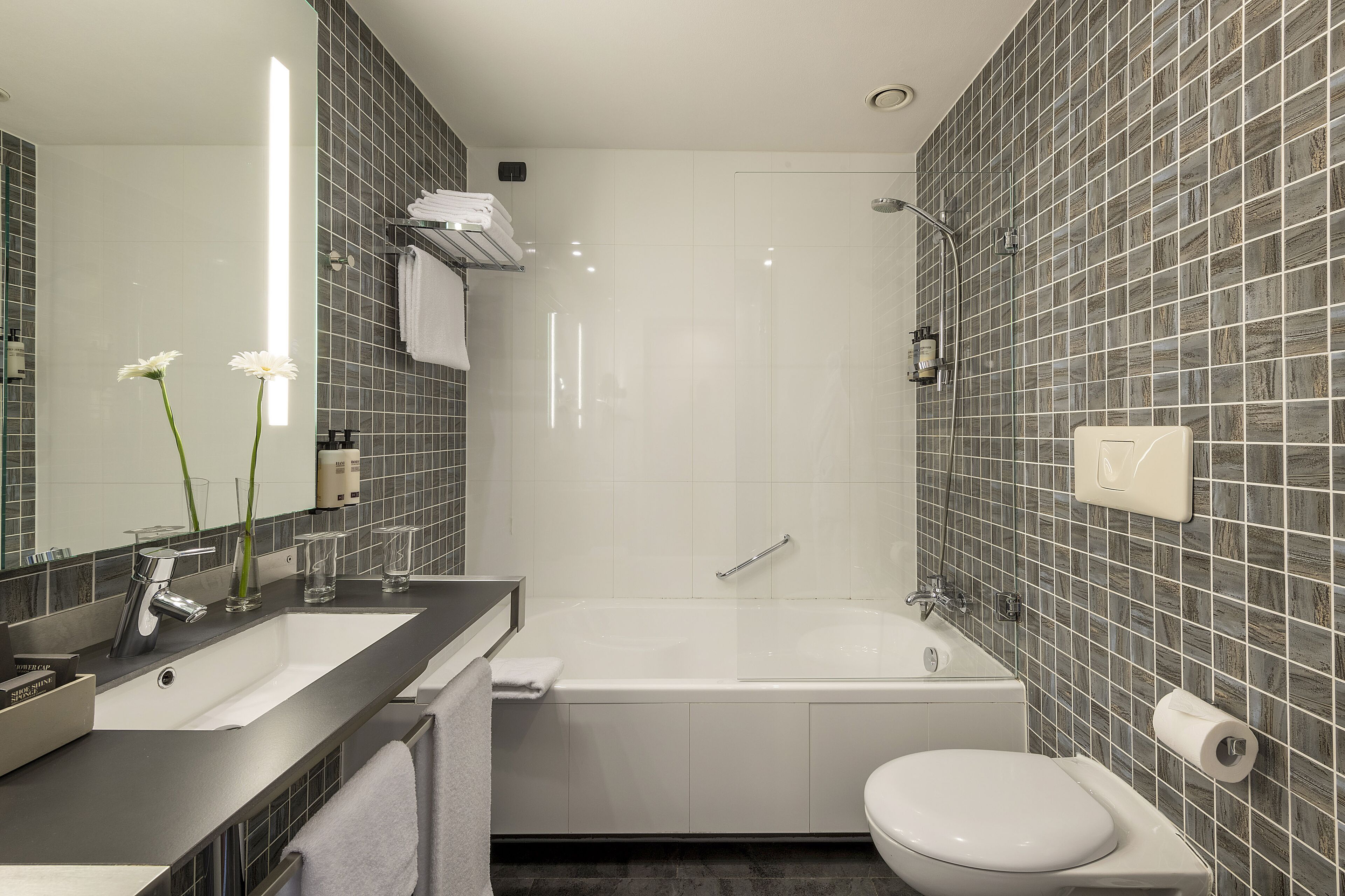 Un bagno moderno con vasca, servizi igienici e lavandino.