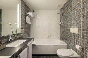 Un bagno moderno con vasca, servizi igienici e lavandino.