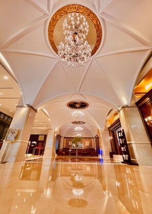 A grand lobby with a high ceiling, ornate chandeliers, and a polished marble floor. - Casa Real Hotel, Macau (Macau)