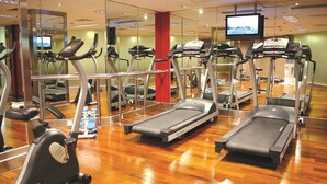 Une salle de sport équipée de tapis de course, de vélos elliptiques et d’un vélo d’appartement.