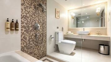 A modern bathroom with a shower, toilet, and sink.