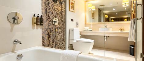 A modern bathroom with a bathtub, toilet, and shower area.