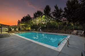 A rectangular swimming pool with a metal ladder and a tiled deck surrounding it. - Holiday Inn Express Hotel & Suites Fairburn by IHG (Fairburn)