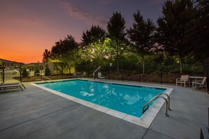 Una piscina al aire libre de temporada, sillones reclinables de piscina