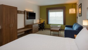 A hotel room with a bed, a desk with a chair, a sofa, a TV, and a window with a view. - Holiday Inn Express Hotel & Suites Fairburn by IHG (Fairburn)