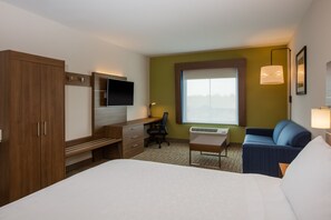 A hotel room with a bed, a desk with a chair, a sofa, a TV, and a window with a view. - Holiday Inn Express Hotel & Suites Fairburn by IHG (Fairburn)