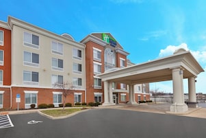 Un hotel Holiday Inn Express con entrada cubierta y estacionamiento.