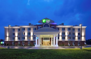 Un hotel Holiday Inn Express & Suites con entrada cubierta y varios pisos.