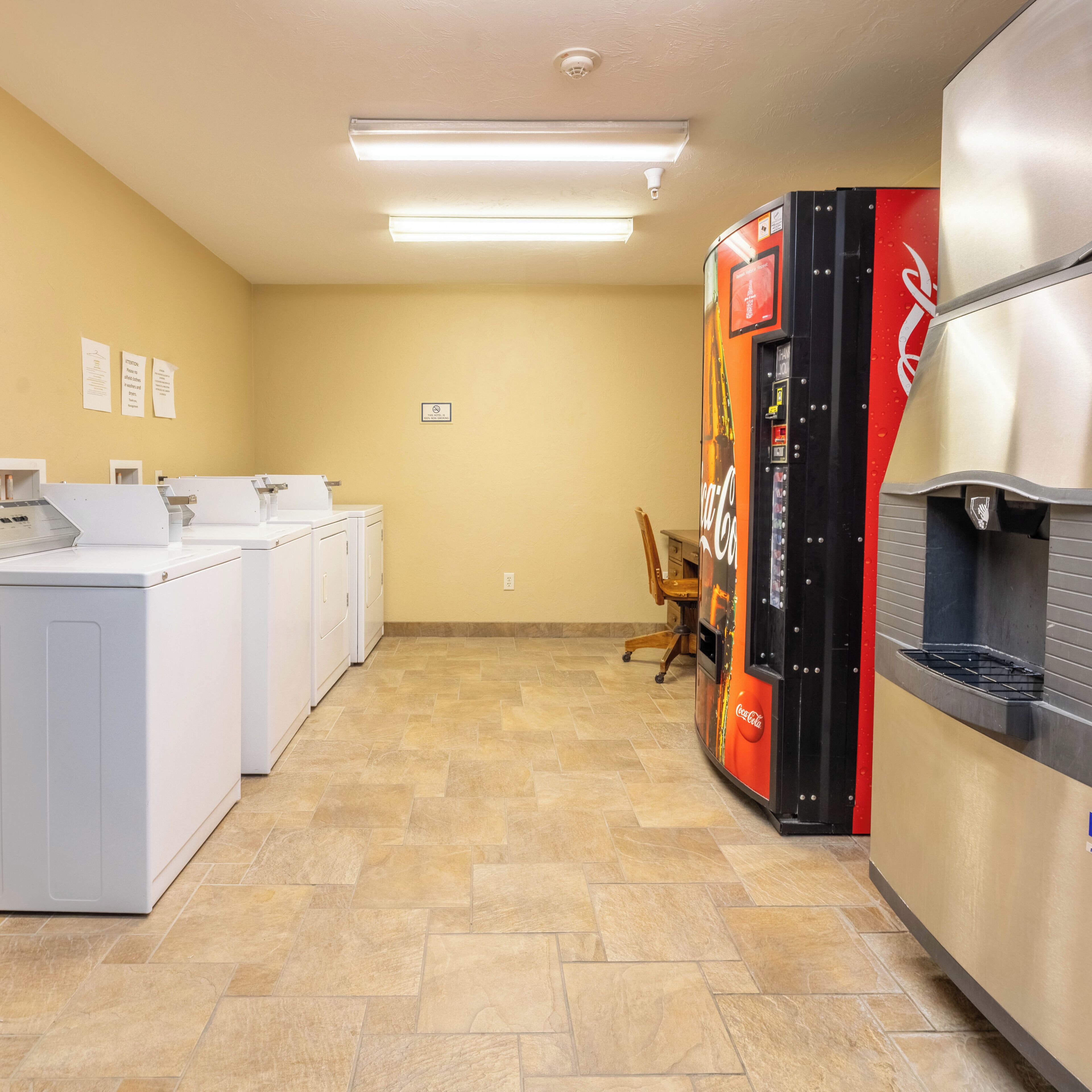 A laundry room with washers and dryers, a vending machine, and a water cooler.