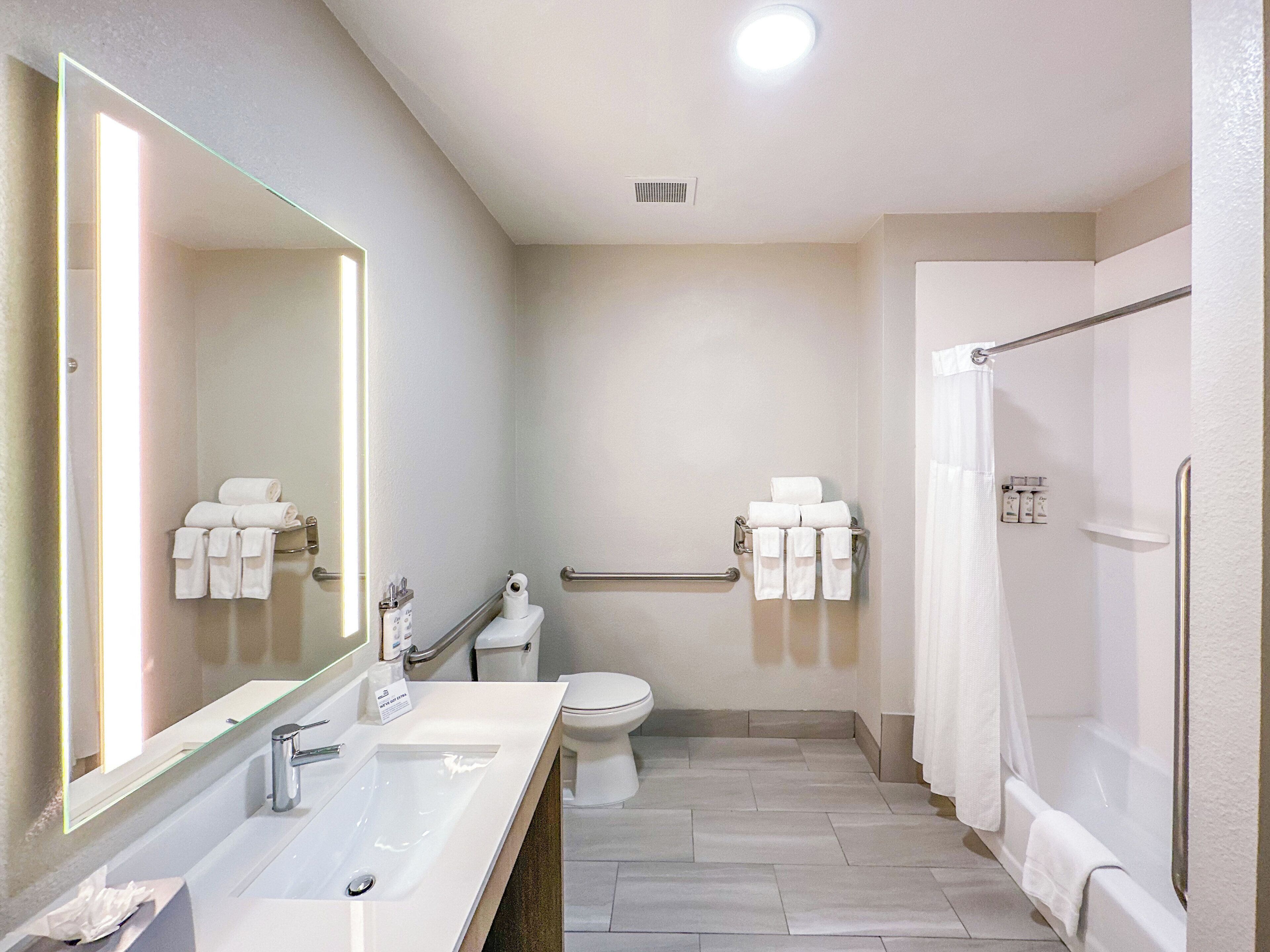 A modern bathroom with a sink, toilet, and shower area.