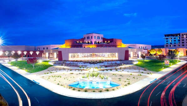 Un hotel moderno con un patio central, una fuente y una piscina.