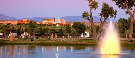 A hotel with multiple buildings, a fountain, and a lake.