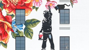 A building with a large mural of a child painting a tree, the name 'Elwood' displayed prominently, and a symmetrical facade with a central entrance. - Elwood Hotel & Suites (Lexington)