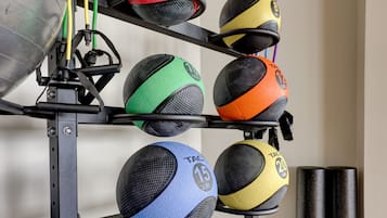 A rack of exercise balls with varying colors and sizes.