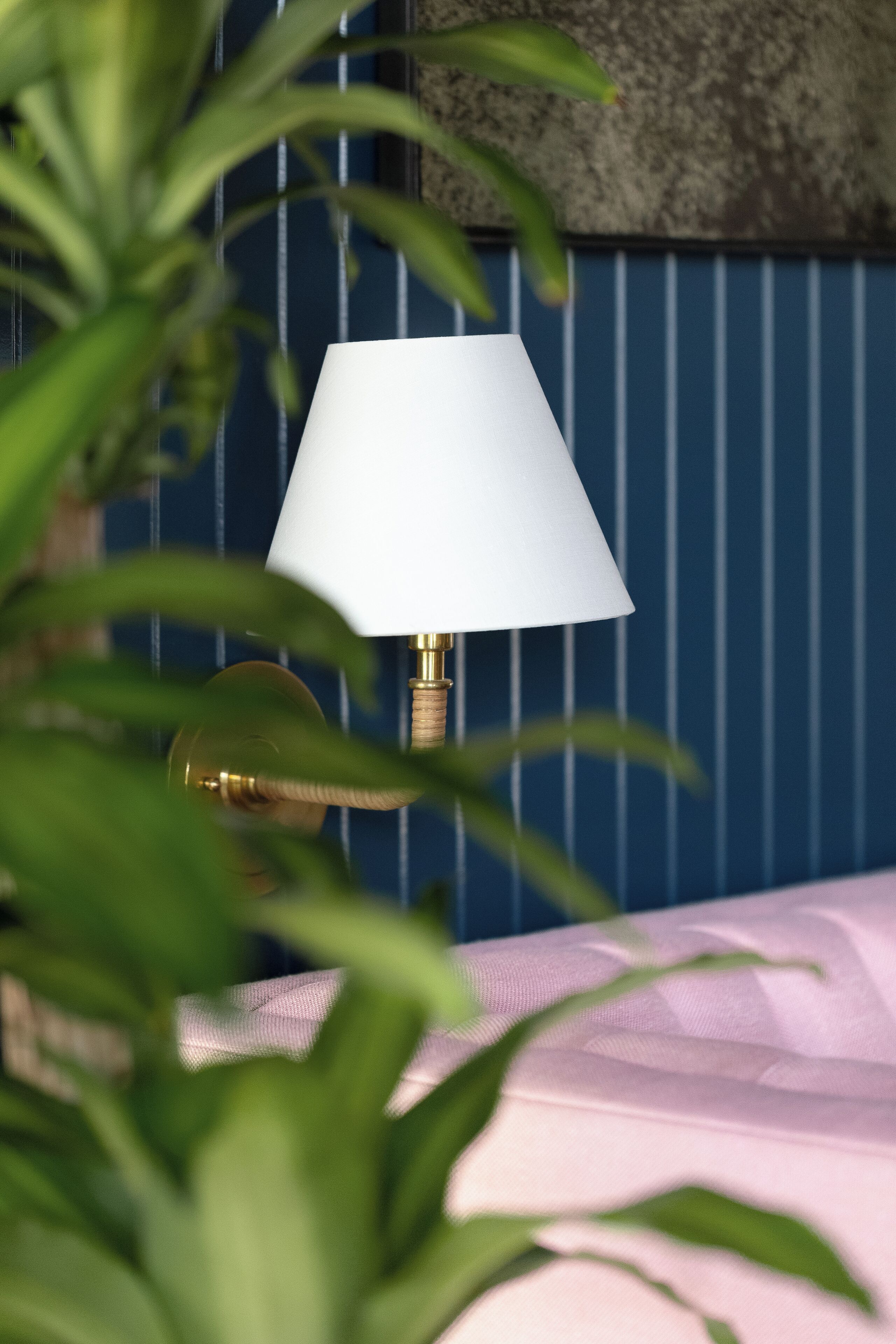 A lamp with a white shade on a bedside table.