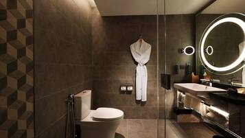 Ein modernes Badezimmer mit Toilette, Bidet und einer Duschkabine aus Glas.