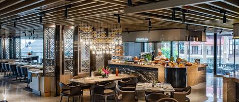 A modern restaurant with a wooden ceiling, a central bar area, and seating arrangements.