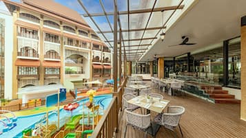 Relax and dine on the deck, surrounded by a pool with a water slide and a boat.