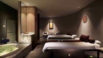 Relax in a spacious room with a large, curved bed, two bedside tables, and a large mirror above.