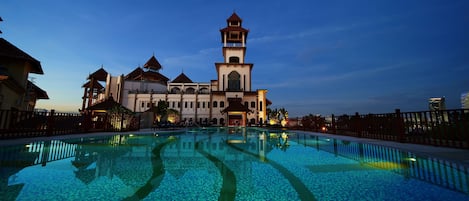 Una piscina al aire libre, sombrillas, tumbonas