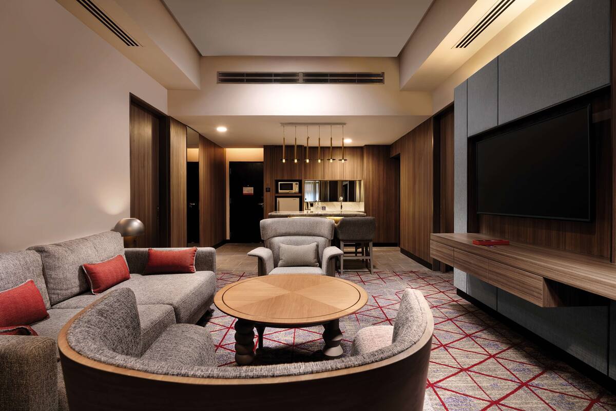 A modern living room with a sofa set, a coffee table, and a TV.