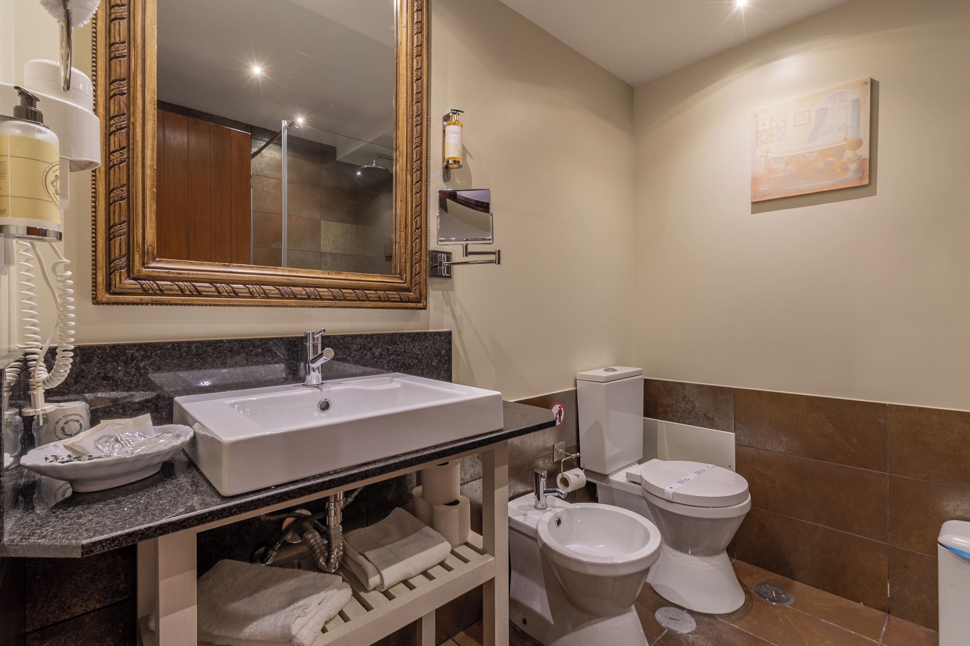 Un baño con lavamanos doble, un espejo grande, inodoro y bidé.