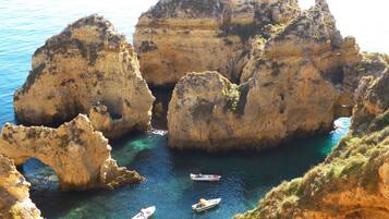 A coastal landscape with rocky cliffs and clear blue waters.