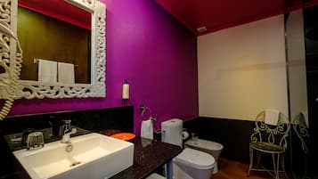 Ein Badezimmer mit einem weißen Waschbecken, einer Toilette und einem Stuhl.