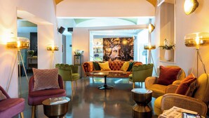 A modern living room with a round coffee table, sofas, and floor lamps. - Leonardo Boutique Hotel Rome Termini (Rome)