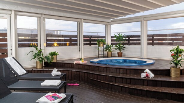 A rooftop terrace with a hot tub, lounge chairs, and potted plants. - Leonardo Boutique Hotel Rome Termini (Rome)
