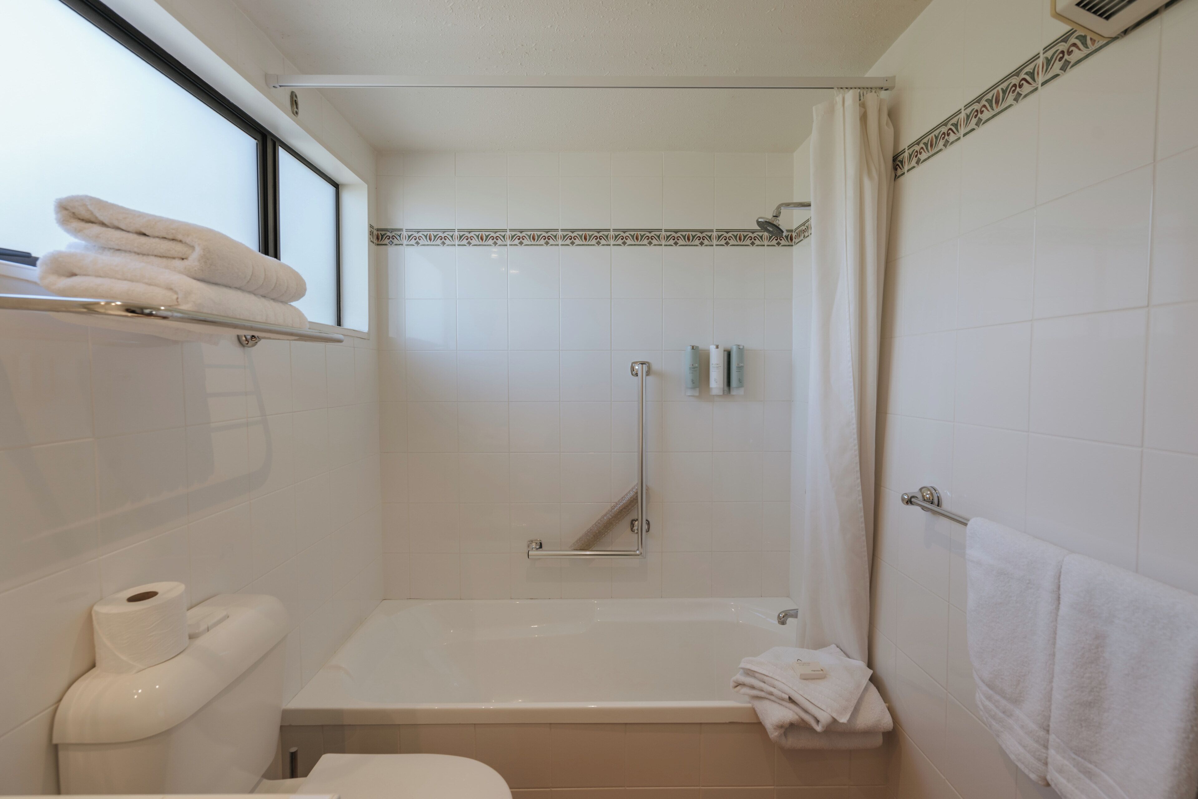 A bathroom with a bathtub, toilet, and a shower area.