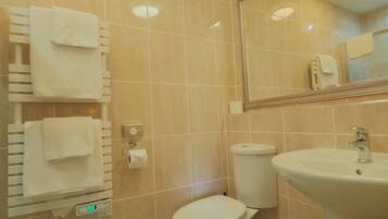 Un bagno con il water, lavandino e porta asciugamani.