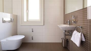 Ein modernes Badezimmer mit Toilette, Waschbecken und Spiegel.