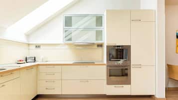 A modern kitchen with a built-in oven, a microwave, and a toaster.