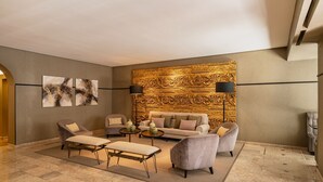 A modern living room with a sofa set, two armchairs, a coffee table, and a rug. - Hotel Vincci Baixa (Lisbon)