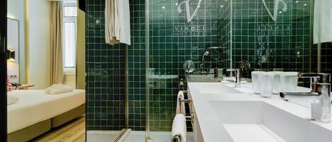 A modern bathroom with a glass shower enclosure, a large mirror, and a white sink with a vanity.