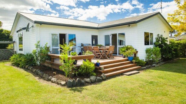 A single-story house with a patio, outdoor furniture, and a barbecue grill. - Tudor Park Motel (Gisborne)