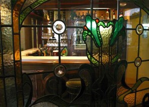 A bar with a green glass partition and a circular mirror. - Victoria Railway Hotel (Invercargill)