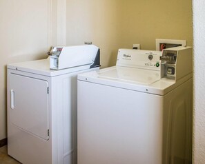 Une buanderie équipée de deux lave-linge et deux sèche-linge Whirlpool blancs.