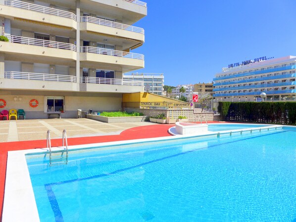 Un hôtel doté d’une piscine, de plusieurs balcons et d’un bar.