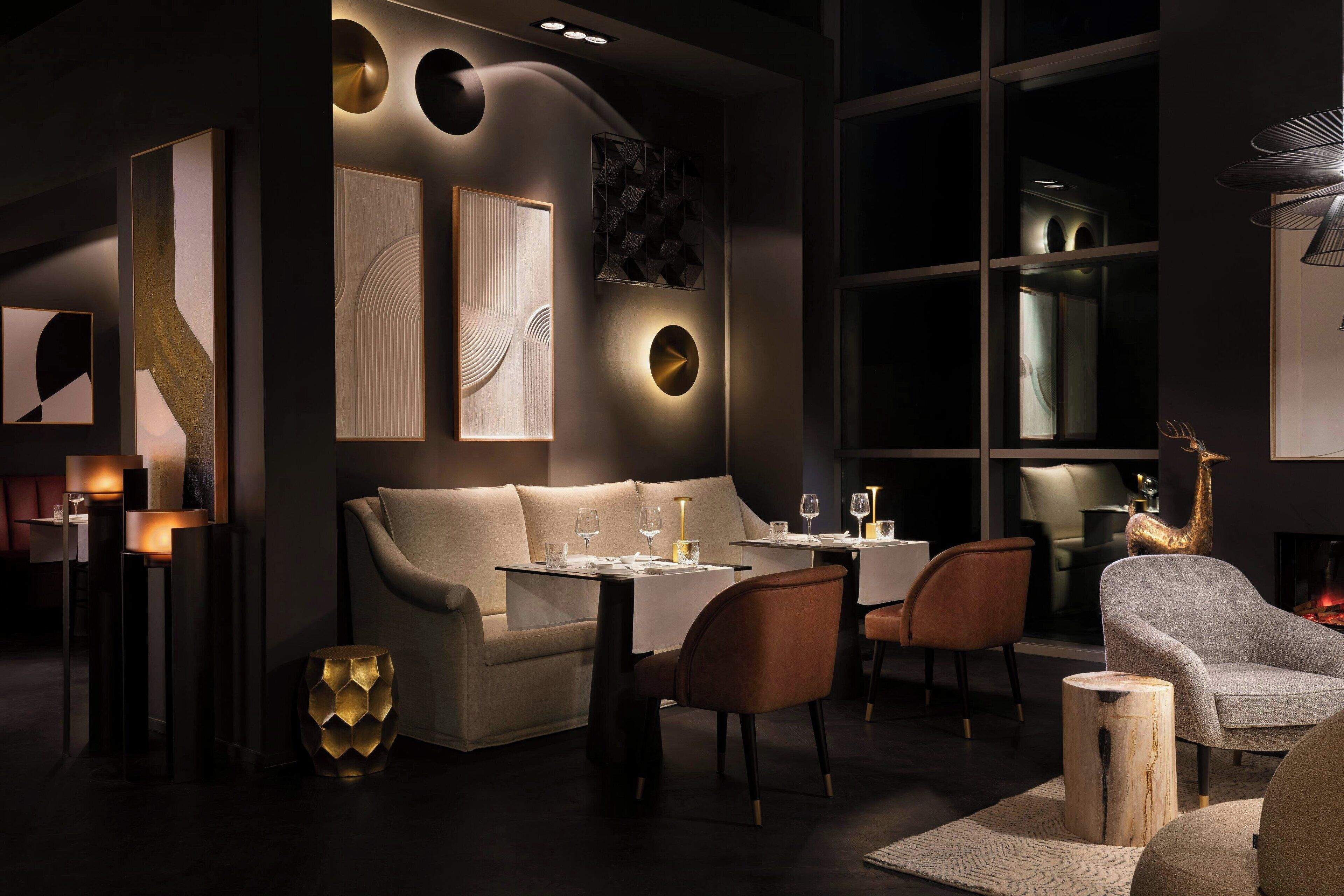 A modern interior with a sofa, dining table, chairs, and abstract wall art.