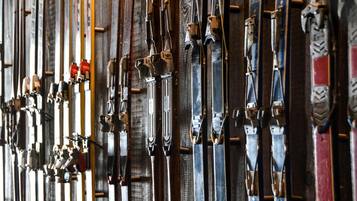 Skis and ski poles hanging on a wooden wall.