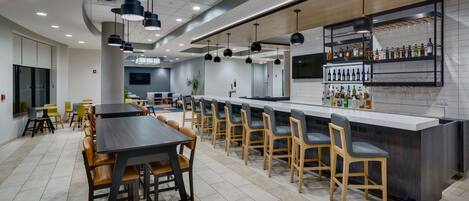 A modern restaurant with a long counter, bar area, and seating for 20 people.