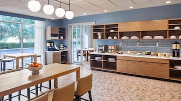 Una cocina moderna con barra desayunadora, armarios de madera y vistas al exterior.