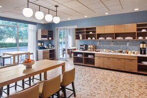 Una cocina moderna con barra desayunadora, armarios de madera y vistas al exterior.