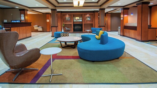 Um hall de entrada com balcão de recepção, área de estar com mesa redonda e lareira.