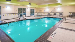 Piscina interior com água cristalina, profundidade demarcada e sinalização de segurança.