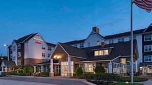 A Marriott Residence Inn hotel with a two-story structure, a covered entrance, and an American flag. - Residence Inn Bryan College Station (College Station)